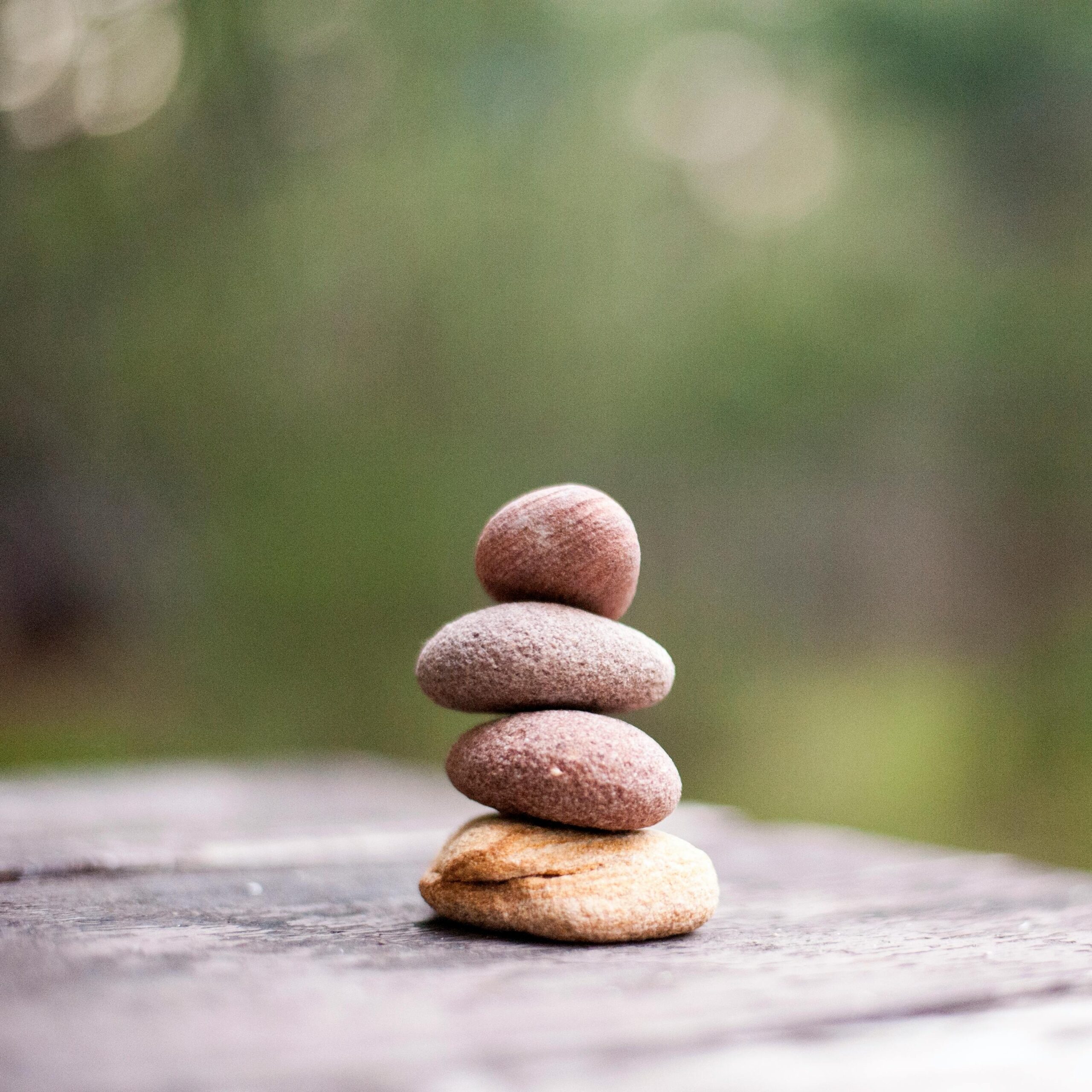 Stacked stones on a wooden surface symbolizing balance and serenity in a natural setting.